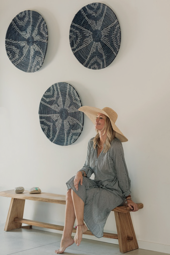 Favela Accessoires — capeline raphia naturel et paniers tressés bleu nuit accrochés au mur, banc bois