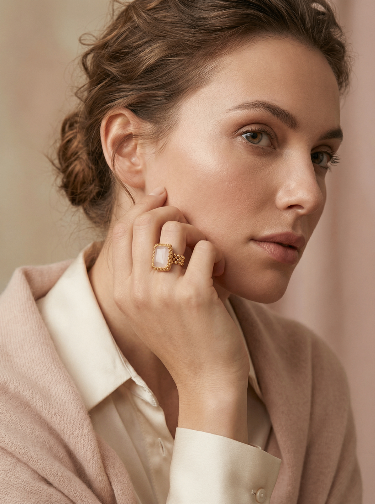 Ibu Jewels — portrait, bague pierre rose carrée sertie d'or, geste à l'oreille